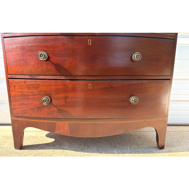 This is an antique handcrafted English mahogany bowfront Chest drawers. This English chest was constructed with flame...