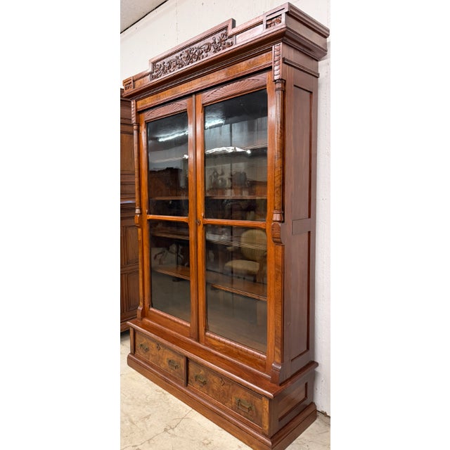 19th century American Victorian hand-carved solid walnut bookcase, circa 1890, featuring burl walnut on the columns,...