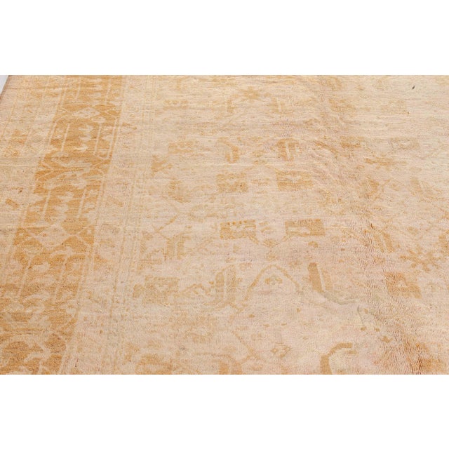 This remarkable antique Oushak rug from Turkey is a stunning example of Anatolian craftsmanship at the turn of the 20th...