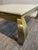 A vintage coffee table by Henredon with a brass frame, travertine top, and Ming-style legs is a high-quality piece of...