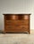 This late 19th century oak chest of drawers features a sculpted serpentine facade, shaped top, and pronounced cathedral...