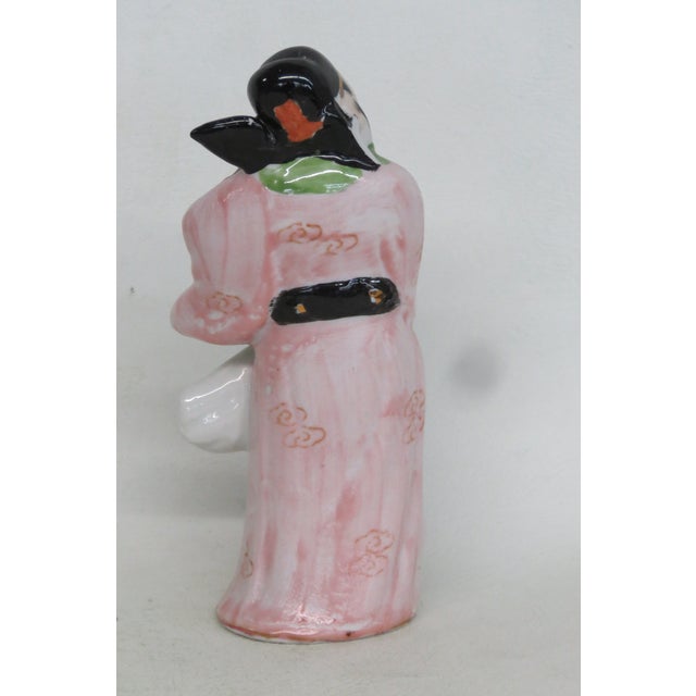 This lovely Chinese Figurine is made out of ceramic. This lovely figurine is a very charming depiction of a smiling man...