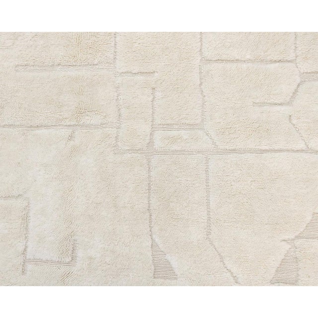 Elegant hand-knotted wool rug in a Natural Wool textured with a subtle flat-woven geometric pattern, ideal for minimalist...