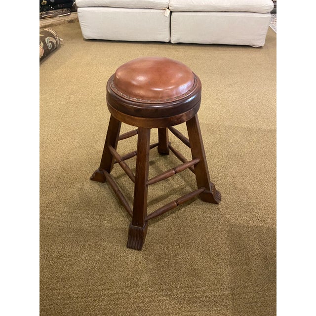 Wood base swivel counter stool features a wood base in a natural warm brown finish with padded seat upholstered in...