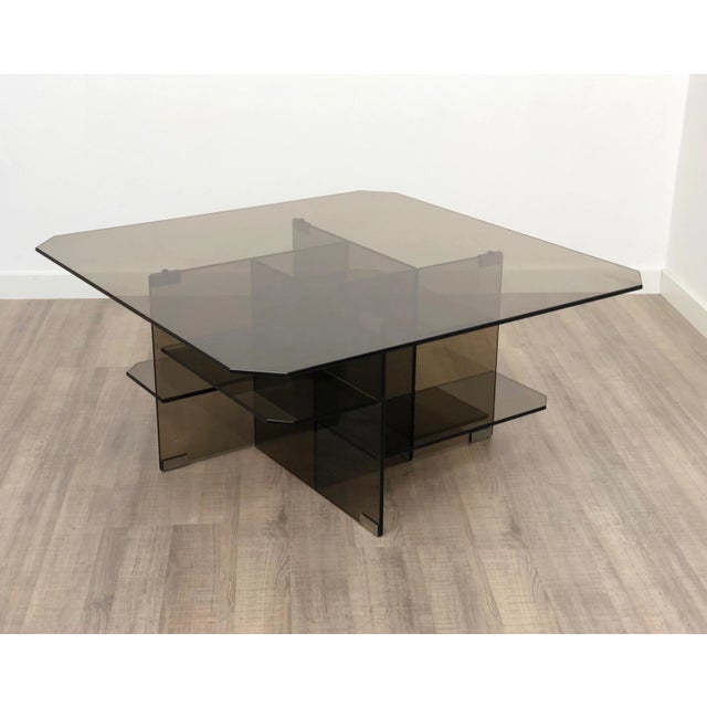 Coffee/side table completely in smoked glass with an abstract sculptural presence that gives it a dynamic style.