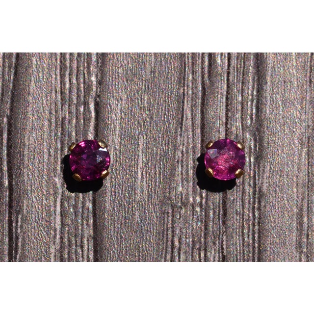 The Gar: Natural Garnet Stud Earrings in Yellow Gold. The earrings feature 3.7mm round brilliant cut natural garnets at...