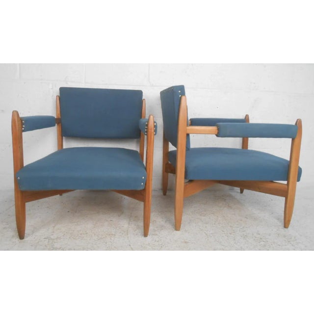 This comfortable pair of midcentury lounge chairs features unique design including wonderful toothpick style tapered...