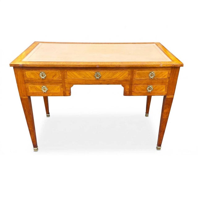A 19th-century French Louis XVI-style centerpiece desk featuring three large drawers on the front, one with a secret...