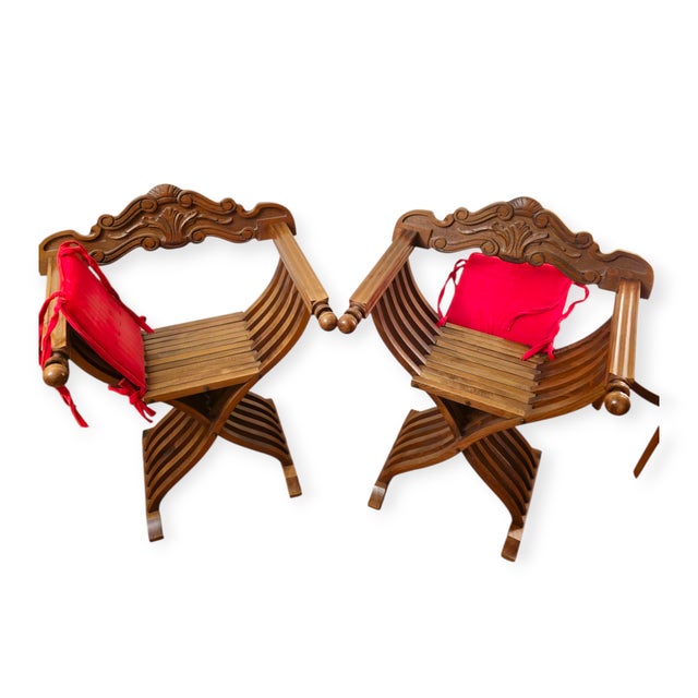 Elegant pair of Renaissance Revival–style wooden folding chairs with architectural lines and refined craftsmanship. Both...