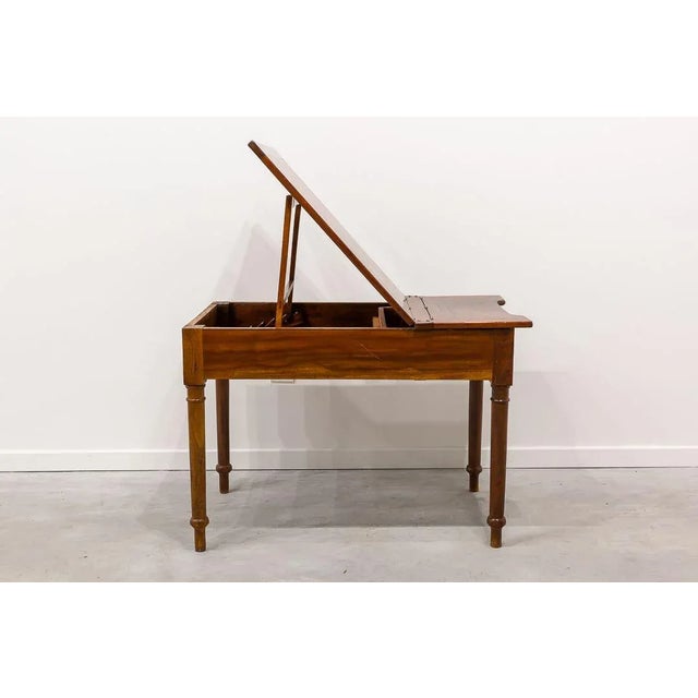 Rectangular work table, with recess on one side, made of oak wood. The lid is divided into two parts that rise, one covers...