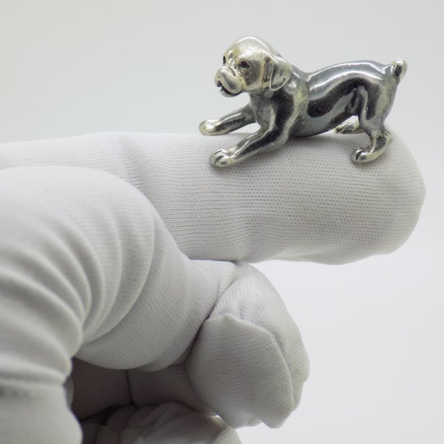 Capturing the endearing energy and charm of a young canine, this vintage silver figurine depicts a playful puppy dog....