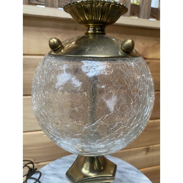 This vintage table lamp looks gorgeous located near a window, with light catching the detailed crackled glass globe; the...