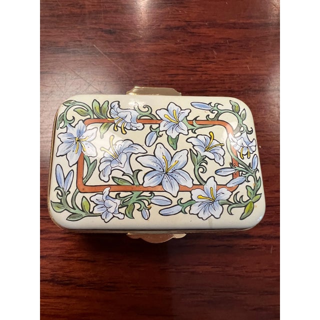 Handpainted enamel box with hinged lid and 24ct gold plated bezels. Made in England by Crummels and Co. Box has lily...