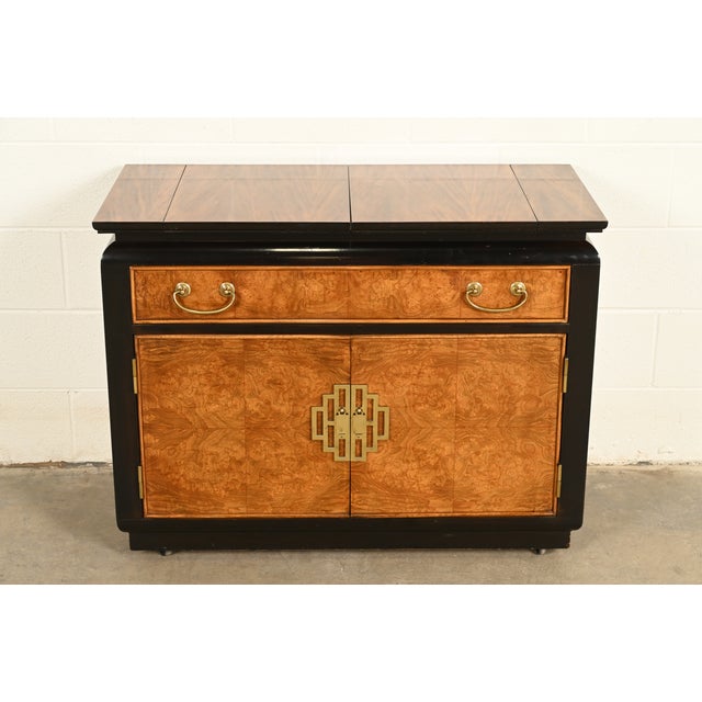 A sleek and stylish mid-century modern Hollywood Regency Chinoiserie flip-top bar cart or buffet server cabinet By Raymond...