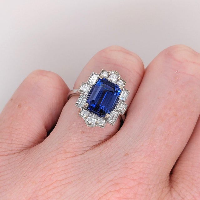 A gorgeous art deco style ring featuring an emerald cut tanzanite with a rich blue color that can compete with a stunning...