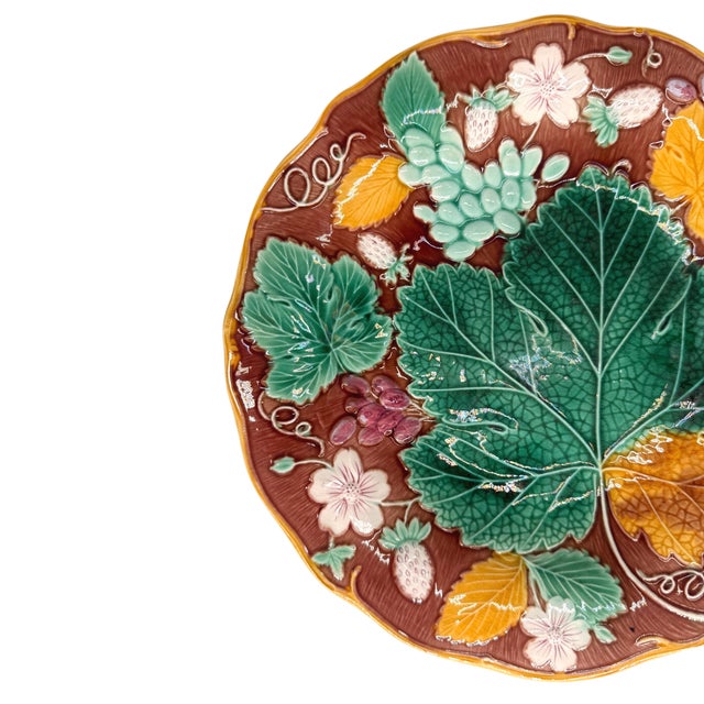 Wedgwood Majolica 'Vine & Strawberry' plate, English, with a large central green grape leaf, purple grapes, strawberries,...