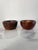 A pair of small turned walnut wood bowls. The bowls have a smooth form and rich grain. They are marked, "Souvenir made at...