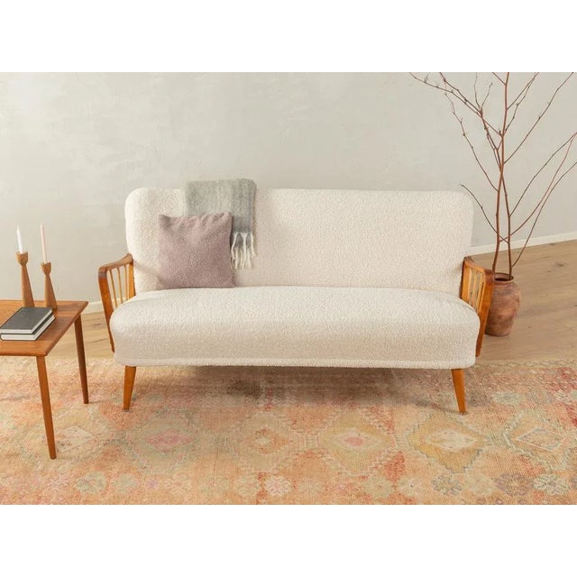 Charming sofa from the 1950s. High quality frame with curved armrests and feet made of beechwood. The original spring core...