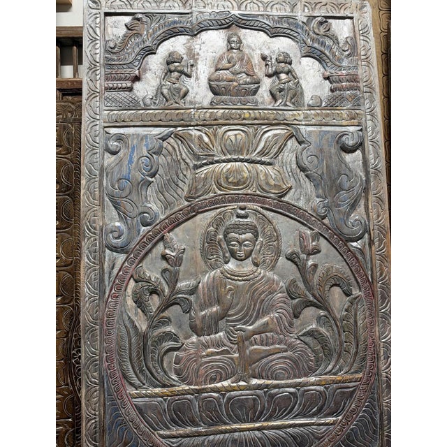 This large hand carved Buddha door panel, featuring a serene Buddha seated on a blooming lotus within a circular medallion...