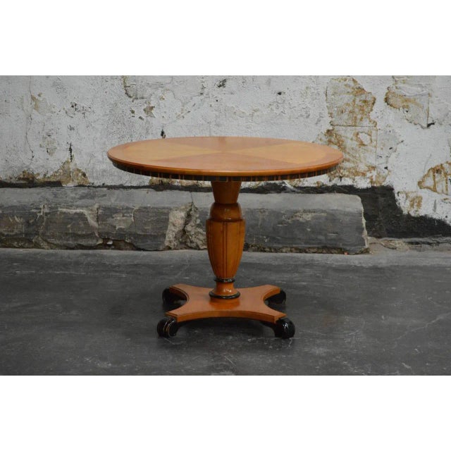 Swedish deco pedestal end or side table in golden elm. The table top is paneled and inlaid with intarsia of contrasting...