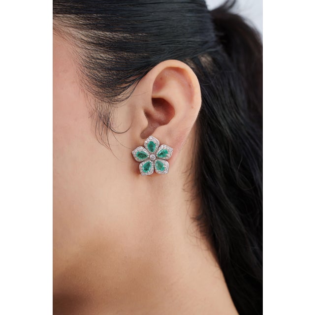 Add timeless elegance to your jewelry collection with these beautiful natural emerald and diamond flower stud earrings....