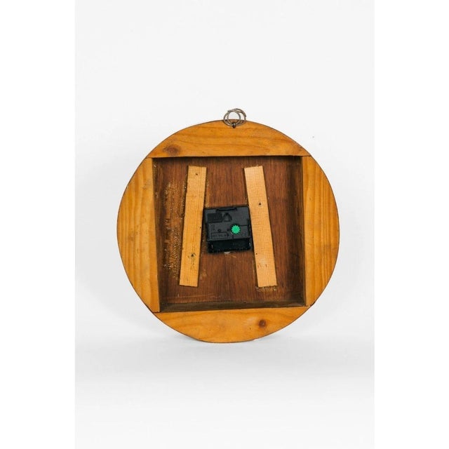 A unique round wooden clock with Roman numerals. The body of the clock consists of a wooden board divided into four...