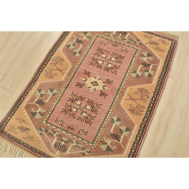 An authentic vintage tribal Milas rug hand-knotted with fine wool and natural dyes. This oriental rug features a small...