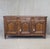 A gorgeous and functional antique early 1800s French oak buffet with three doors and three drawers that sits on curved...