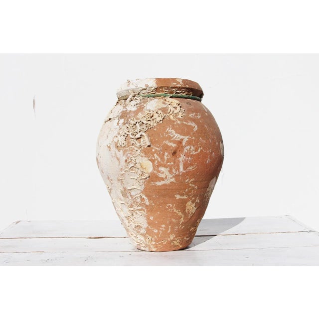 An hand made terracotta pot originally submerged under sea and used as a trap for an individual octopus. This pot has a...