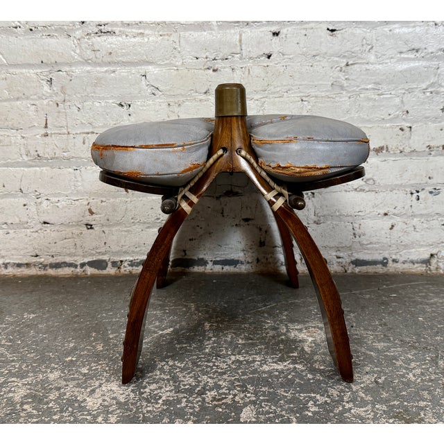 This vintage camel saddle footstool is read to bring an old world feel to any home. Made with a solid construction it...