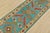A tribal Caucasian Kazak runner hand-knotted with fine wool on a cotton foundation. This rug features geometric motifs set...