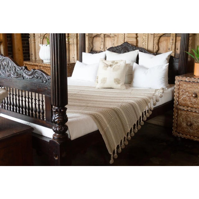 A hand-loomed cotton throw. Soft in texture, with woven stripes and accented with pom-poms on both ends. Beautiful throw...