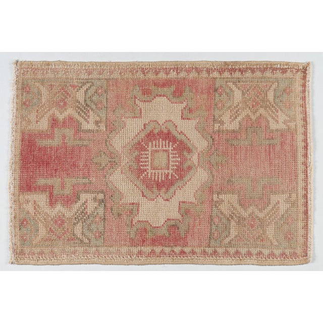 This vintage hand knotted Turkish tribal door mat rug showcases a beautifully timeworn aesthetic with soft, earthy tones....