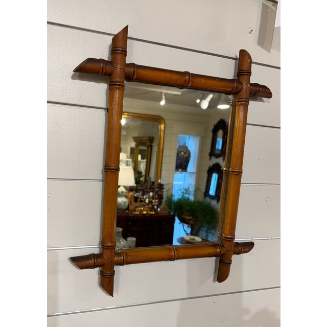 This is a French antique faux-bamboo wall mirror with a hand-carved wood frame. The frame is wood that has been shaped and...