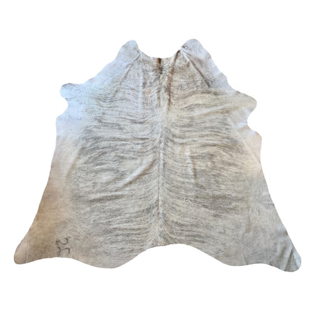 Oversized natural Brazilian hair-on cowhide rug featuring the distinct brindle striping concentrated along the backbone...