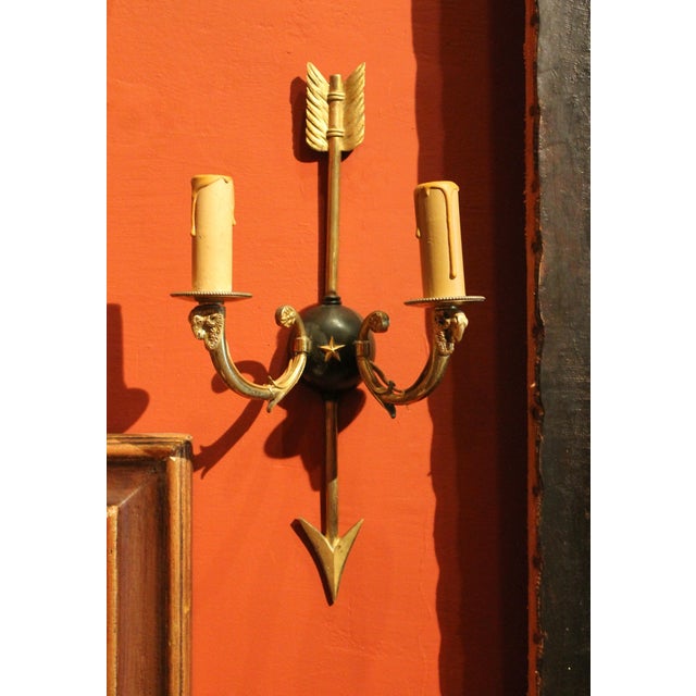Chic pair of gold and black french mid-century modern wall sconces in the manner of maison bagues with a neoclassical...