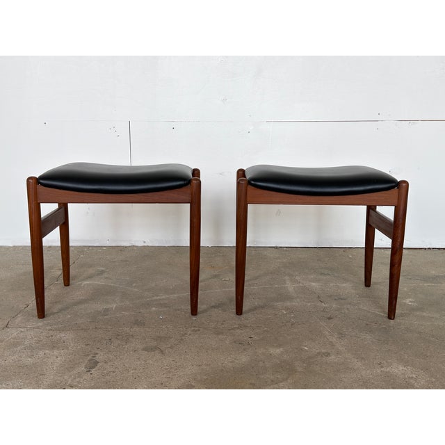 A matched pair of solid teak stools with black leatherette upholstered seat pads, Danish workshop cabinetmaker, 1960s. The...