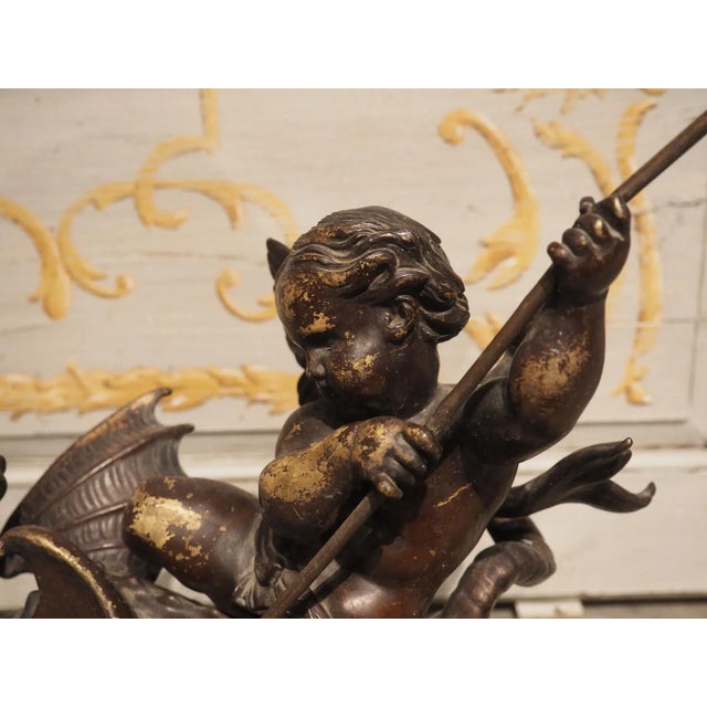 This dynamic pair of French bronze chenets with putti and sea dragons was crafted circa 1850. The dore Rococo bases are...