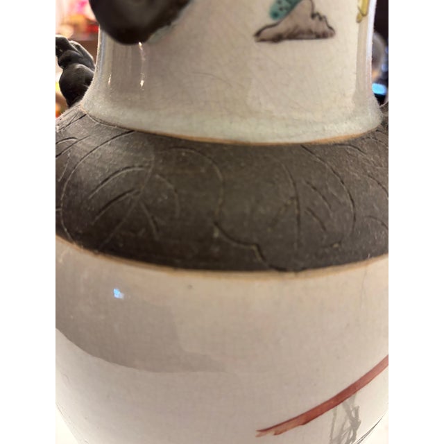 Vibrant colors in orange and celadon on crazing, beige backgrounds, dark brown accents, and handles and base. Comes with...