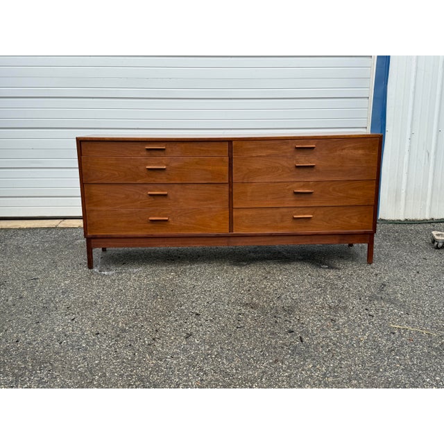 A handsome vintage Mid-Century Modern walnut credenza / dresser featuring warm wood tones, clean architectural lines, and...