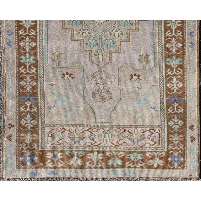 This vintage Turkish Oushak rug (circa mid-20th century) features a unique blend of colors. The multi-layered central...