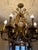 This exquisite vintage chandelier features an ornate gilt metal frame adorned with scrolling arms, leaf and floral motifs,...