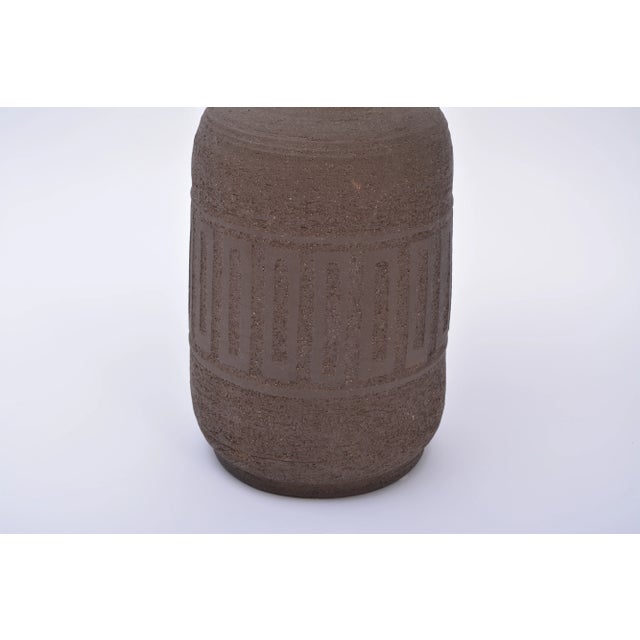 This large floor lamp is made of unglazed stoneware and was produced in Denmark. The lamp features a graphic pattern and a...