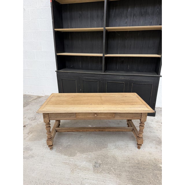 This antique coffee table has been completely restored. It features a small, functional drawer and a carved wooden base. I...
