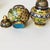 This is a striking pair of vintage cloisonné enamel lidded jars, crafted from a copper body with intricate wire inlay....