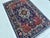Caucasian Karachoph Kazak design hand-knotted rug featuring a bold stepped octagonal medallion in sky blue with a crimson...