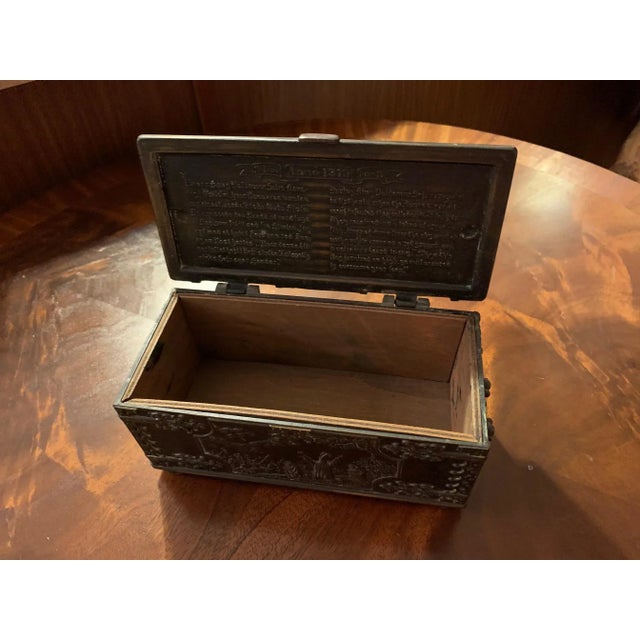 A vintage Iron Art Denmark cast iron casket box. The rectangular shape box has a hinged lid, handles to the sides, and...