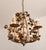 A highly decorative, gold-colored chandelier with rose and leaf embellishments. beautiful vintage chandelier in a floral...