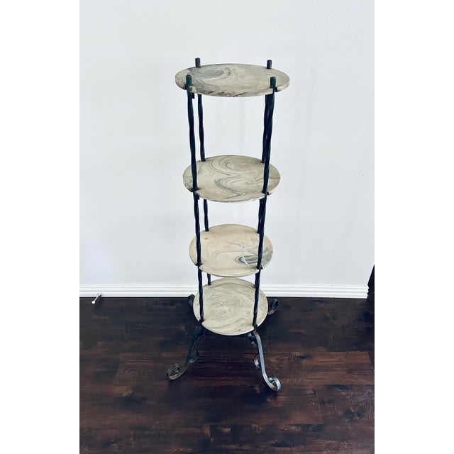 Vintage late 20th century round 4-tiered etagere with wrought iron pillars with scroll legs and beautiful solid, black and...
