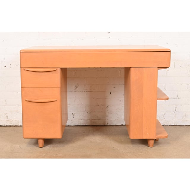 A sleek and stylish Mid-Century Modern writing desk with built-in bookcase By Heywood Wakefield USA, 1950s Sculpted solid...